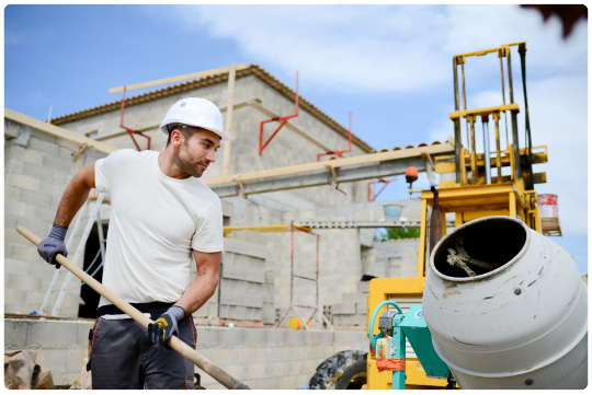 Profissional trabalhando em obra com betoneira ao lado
